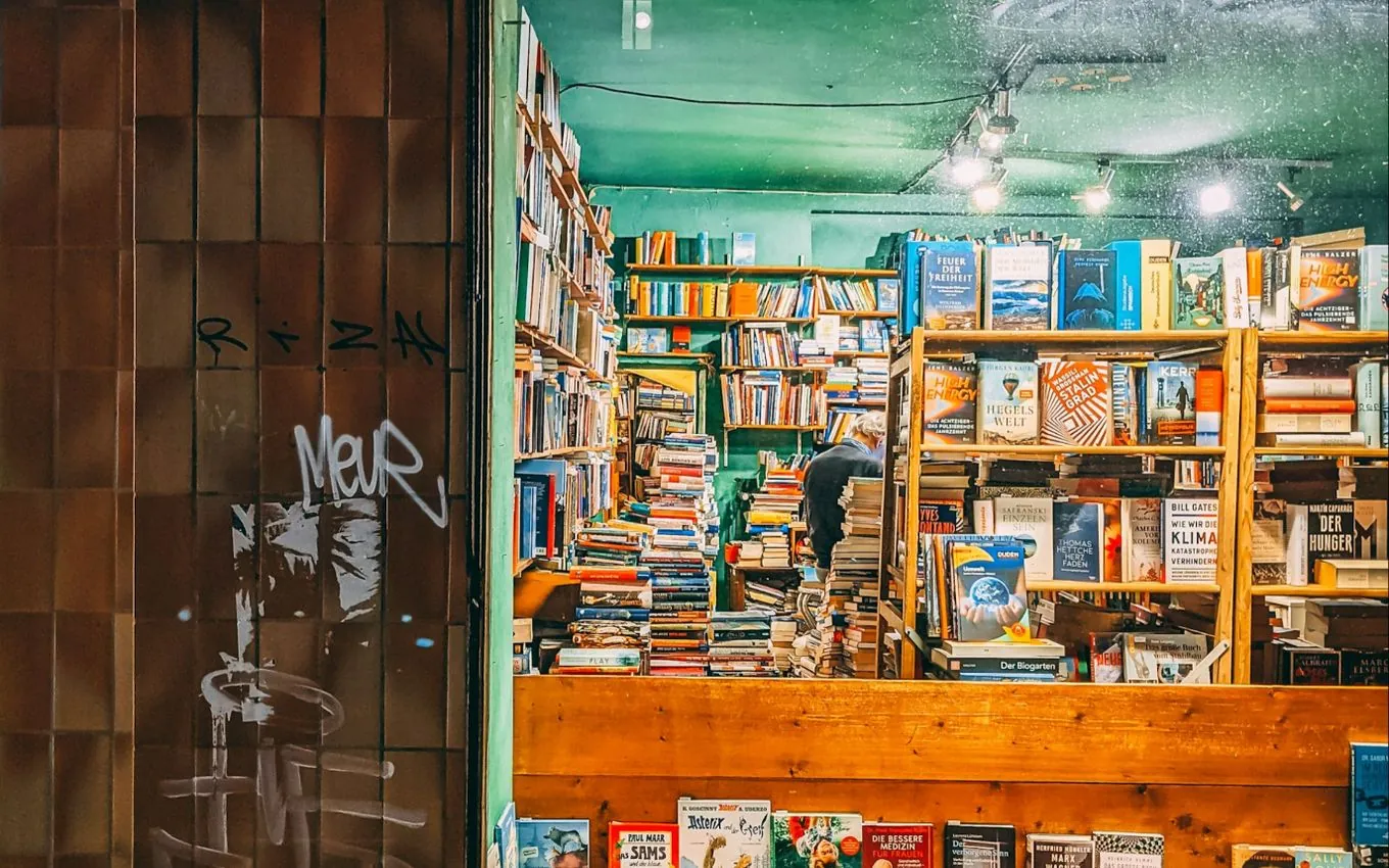 A small bookshop seen through its window at night