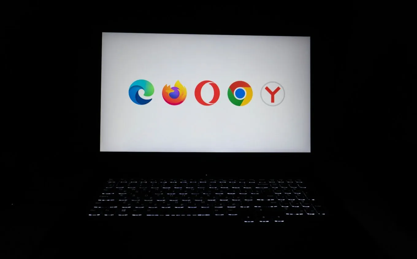 Browser logos on a laptop screen in a dark room