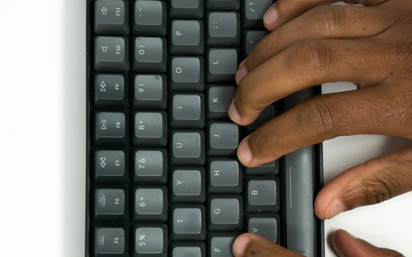 Hands typing on a dark keyboard