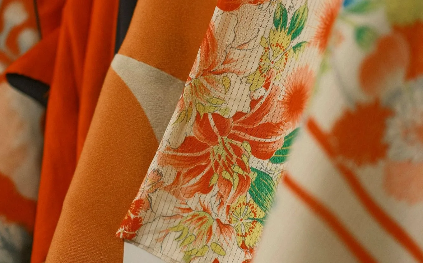 Close-up of kimono fabrics in orange, cream and green with floral prints